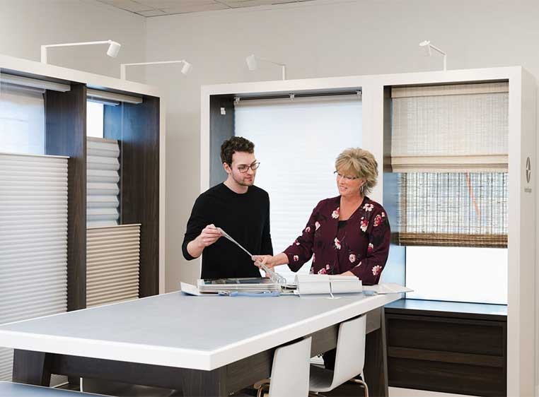 A man and woman in a meeting room looking at some documents